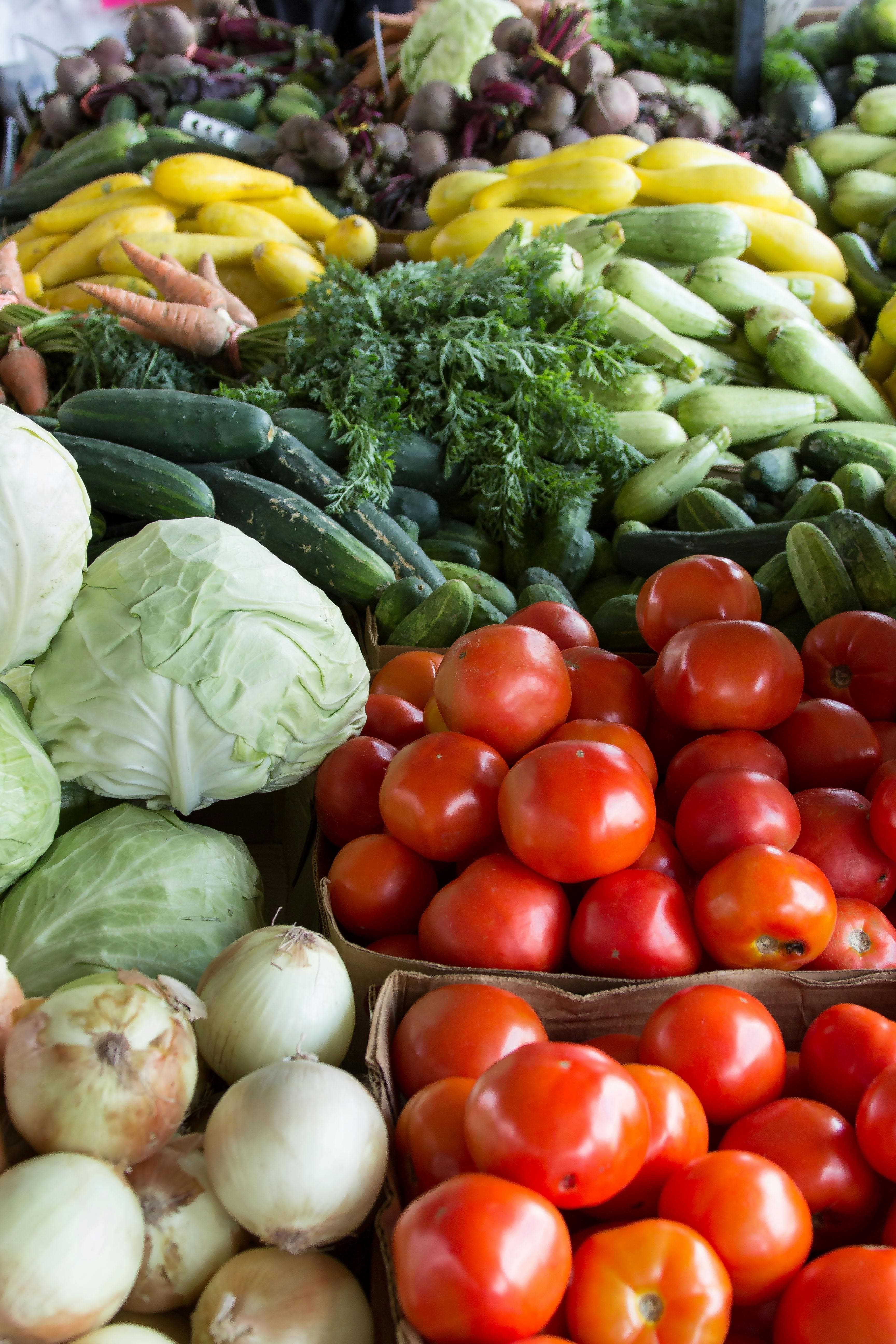 Fresh spring vegetables including asparagus, peas, and leafy greens at a farmers market