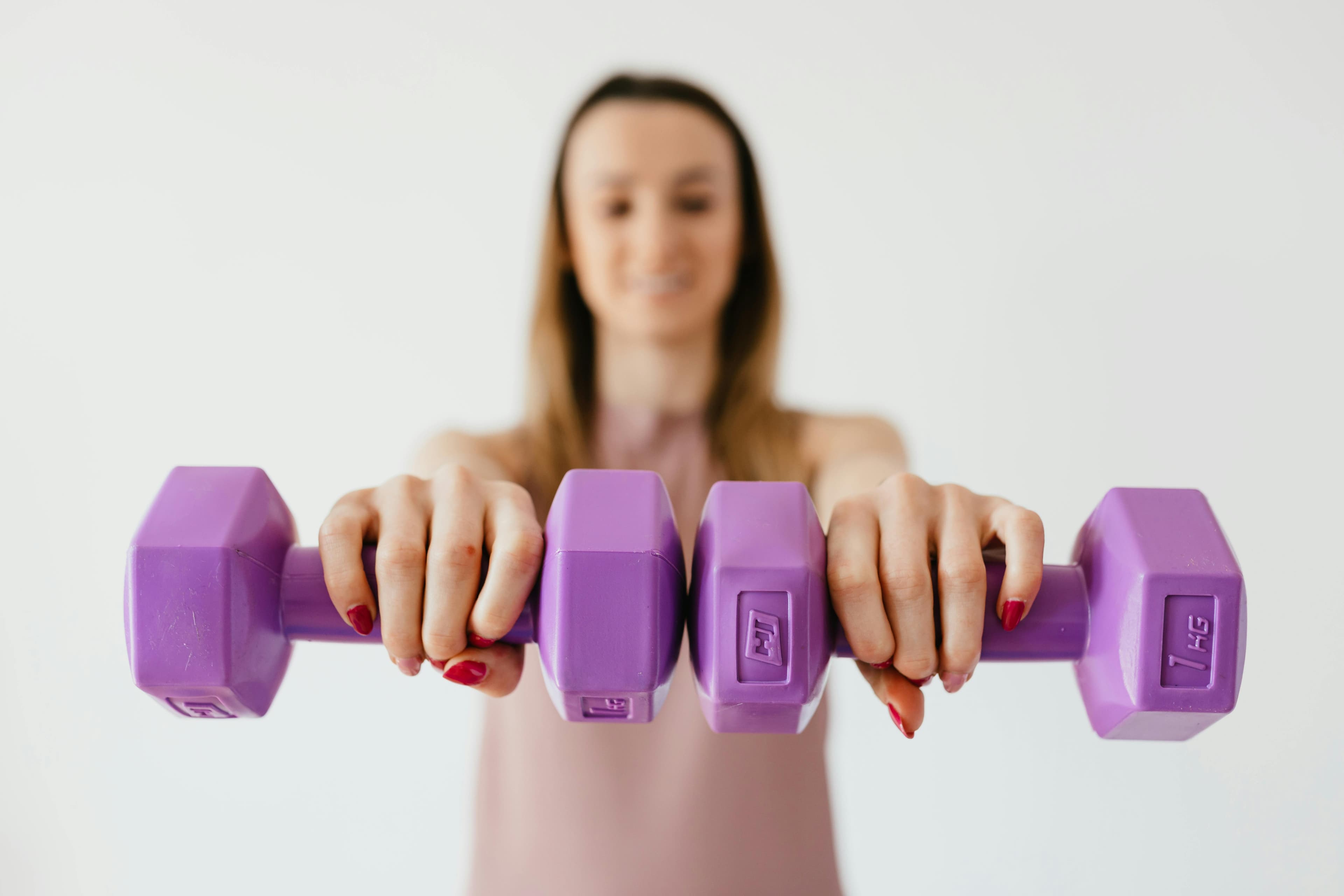Confident woman in her 50s exercising with weights for menopause weight management
